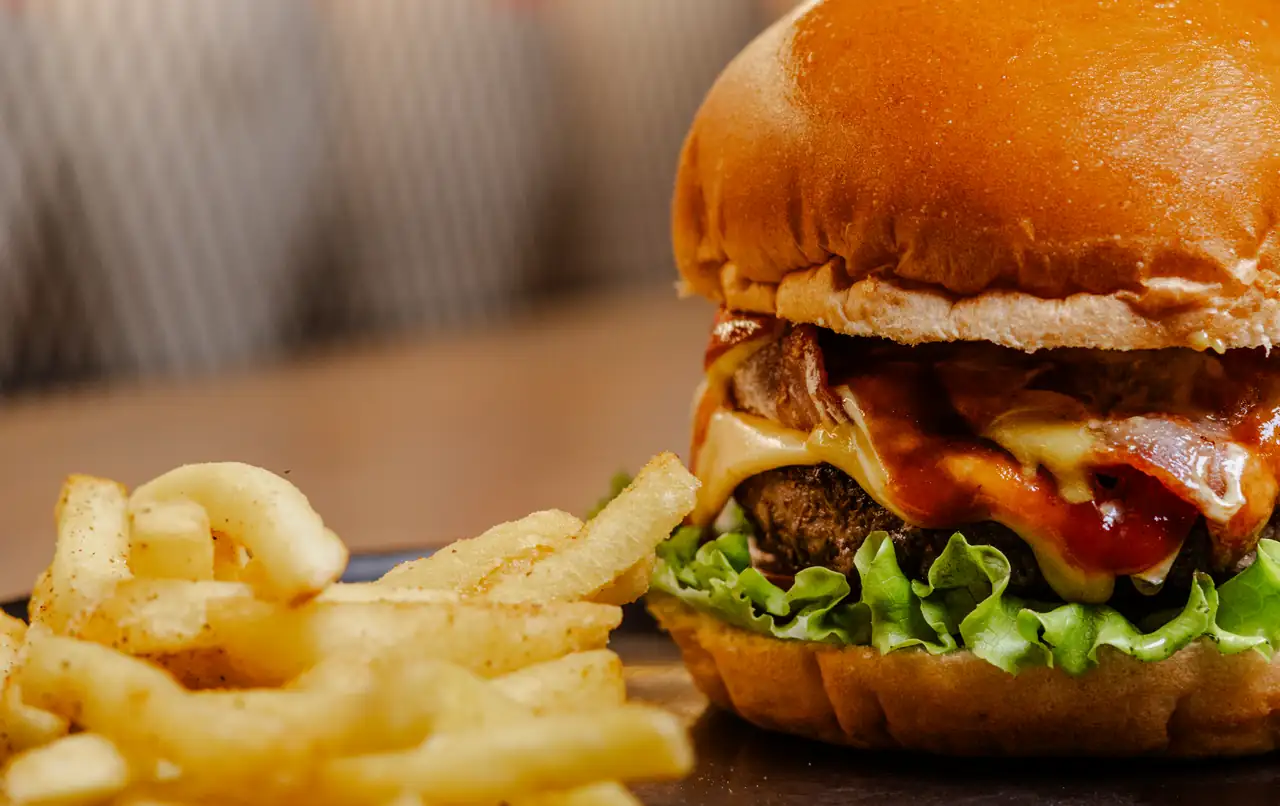 Hamburguesa de res con queso, tocineta y papas a la francesa