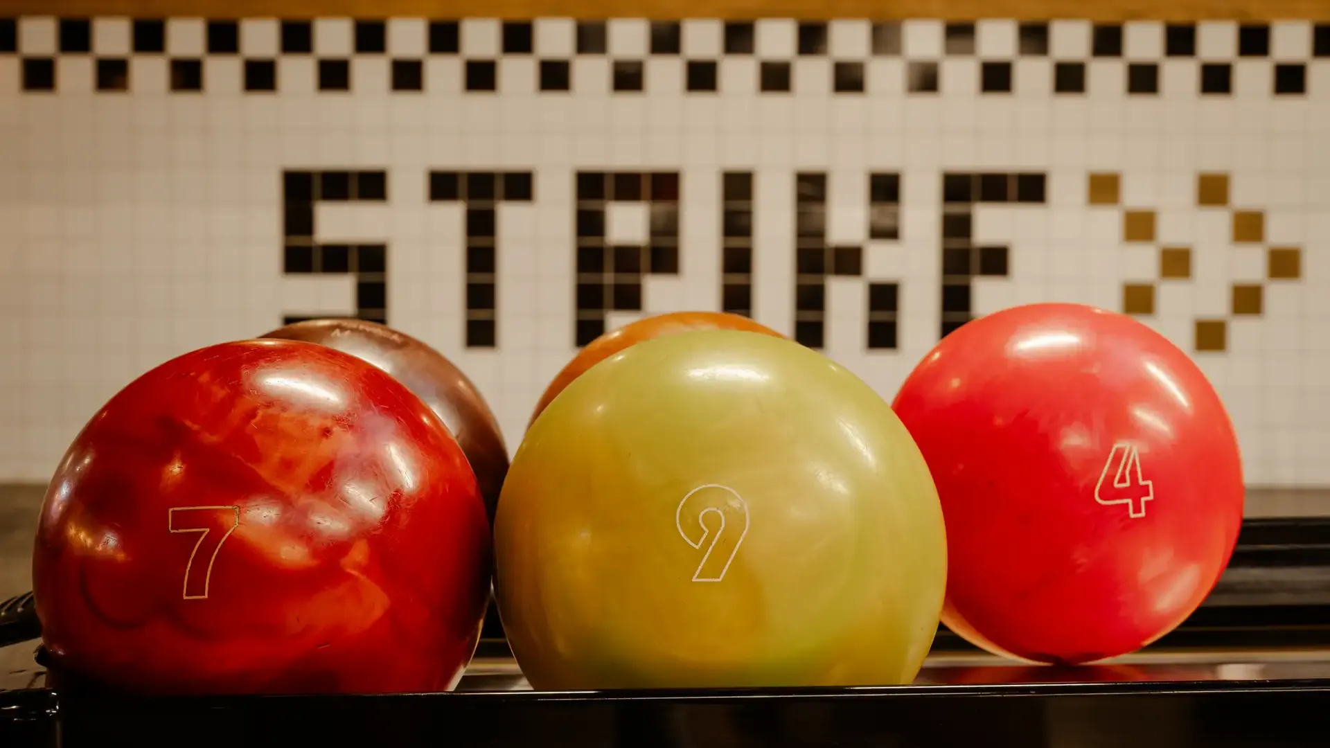 Bolas de bolos de colores junto al letrero Strike.