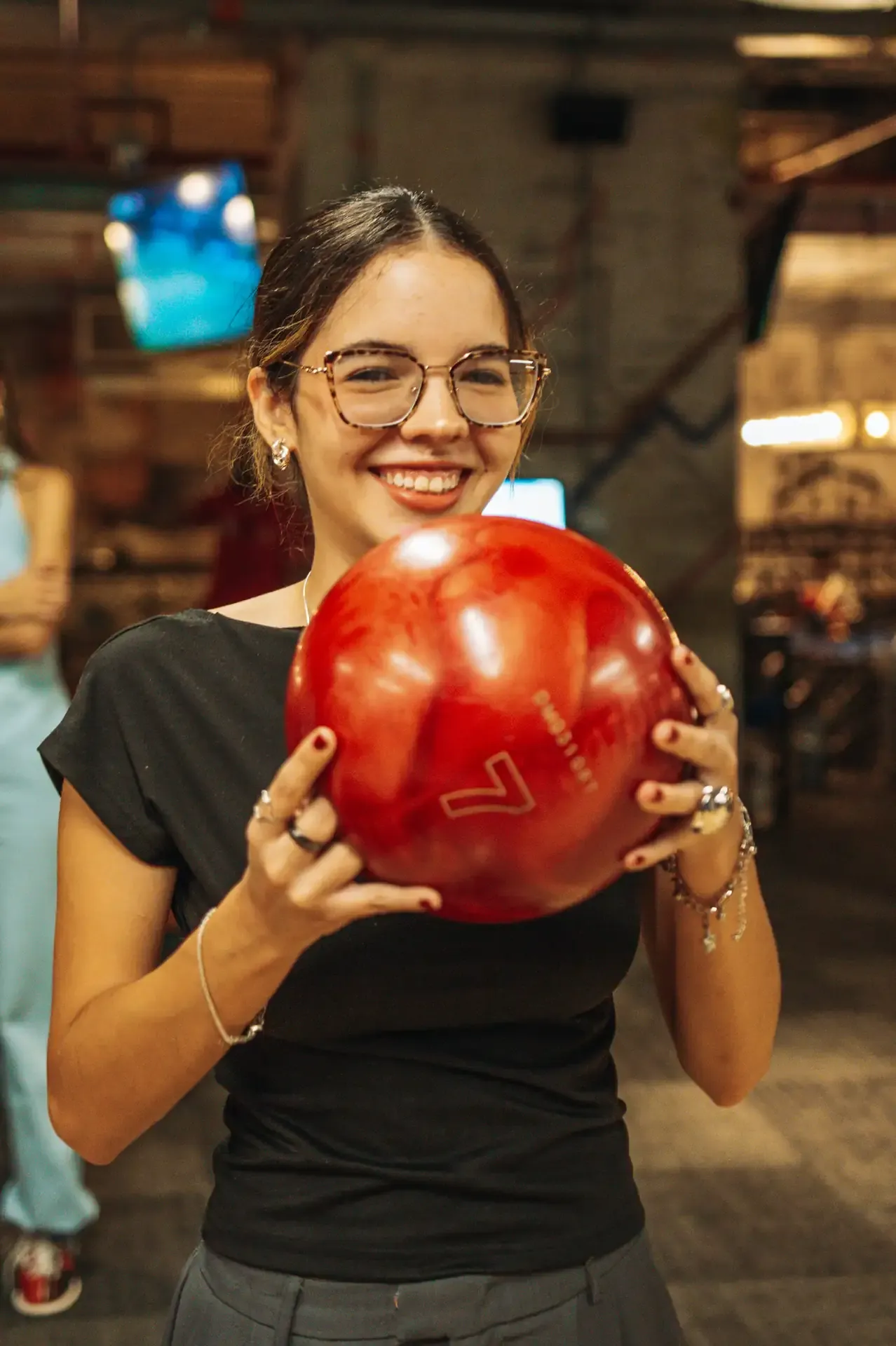 Joven sostiene una bola roja antes de jugar.