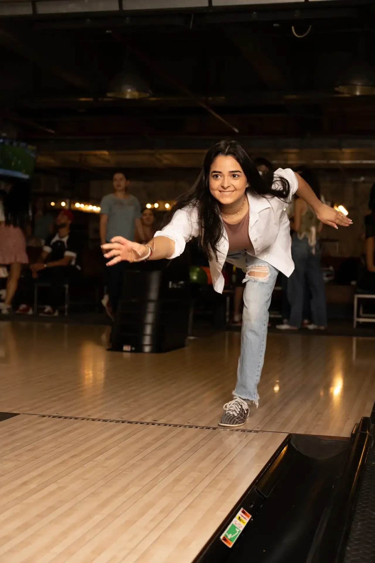 Jugadora lanza una bola en una pista de bolos.