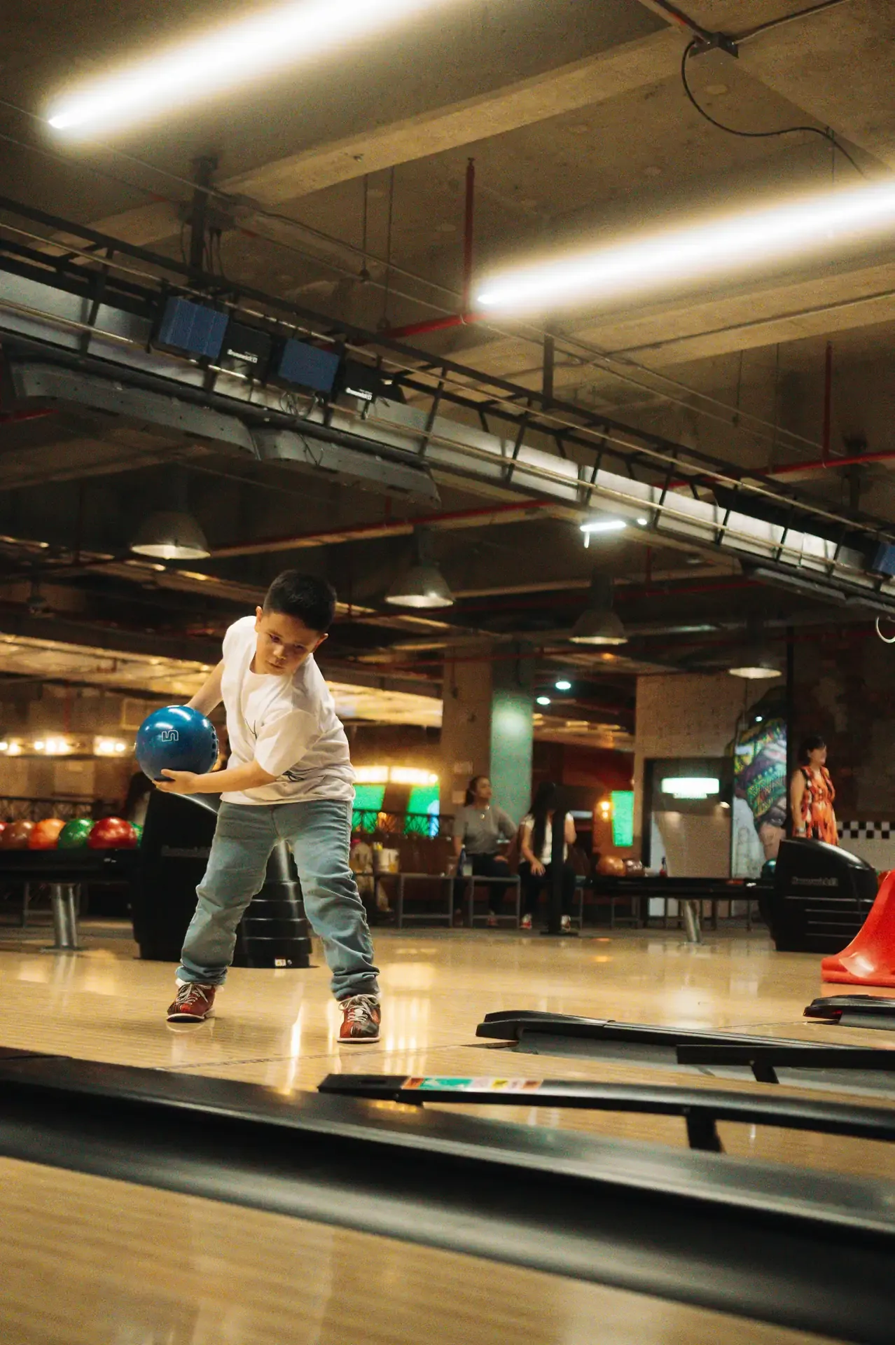 Jugadora toma impulso en una pista de bolos.