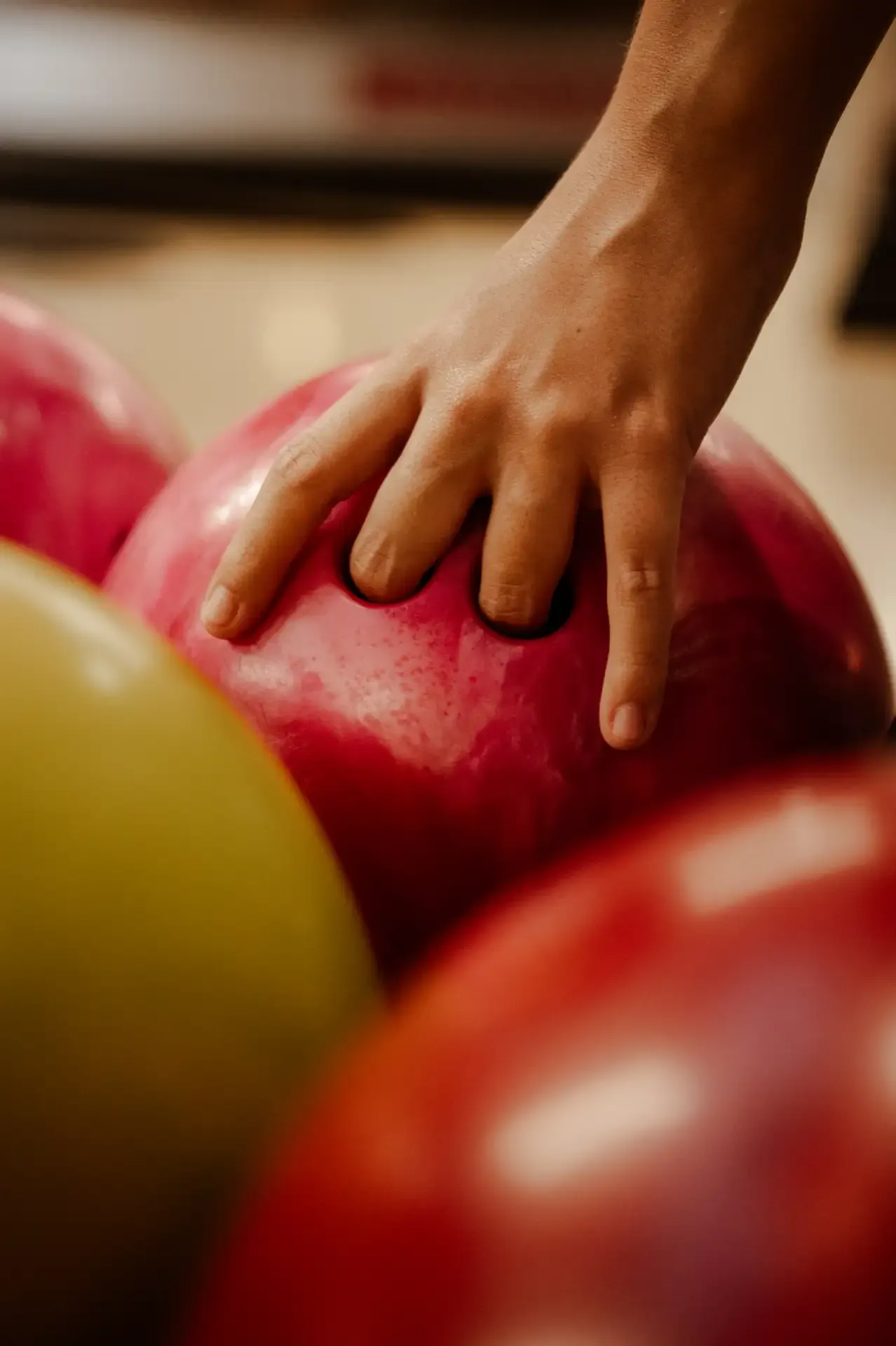 Mano elige una bola verde entre bolas de colores.
