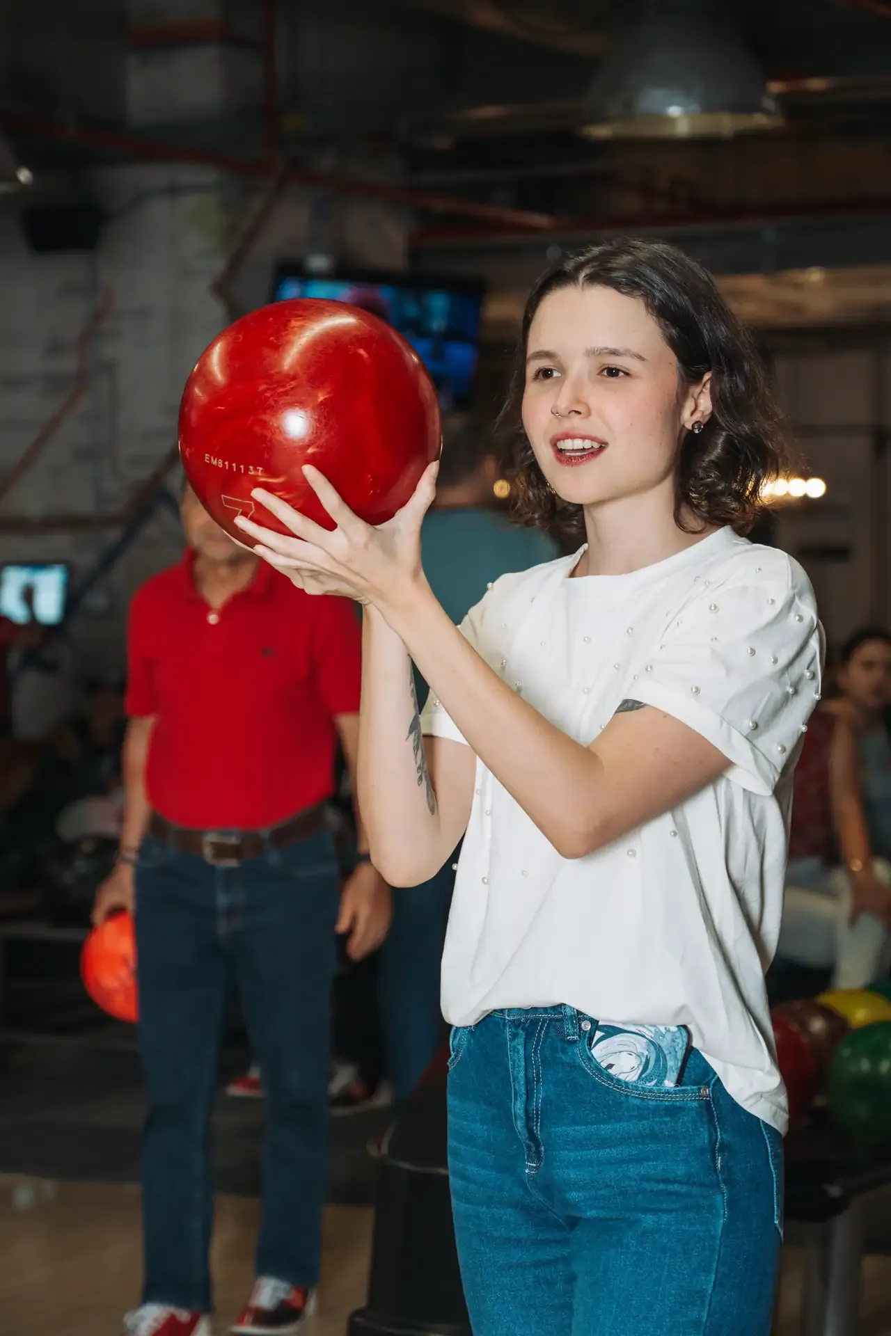 Niña sostiene una bola roja antes de jugar.