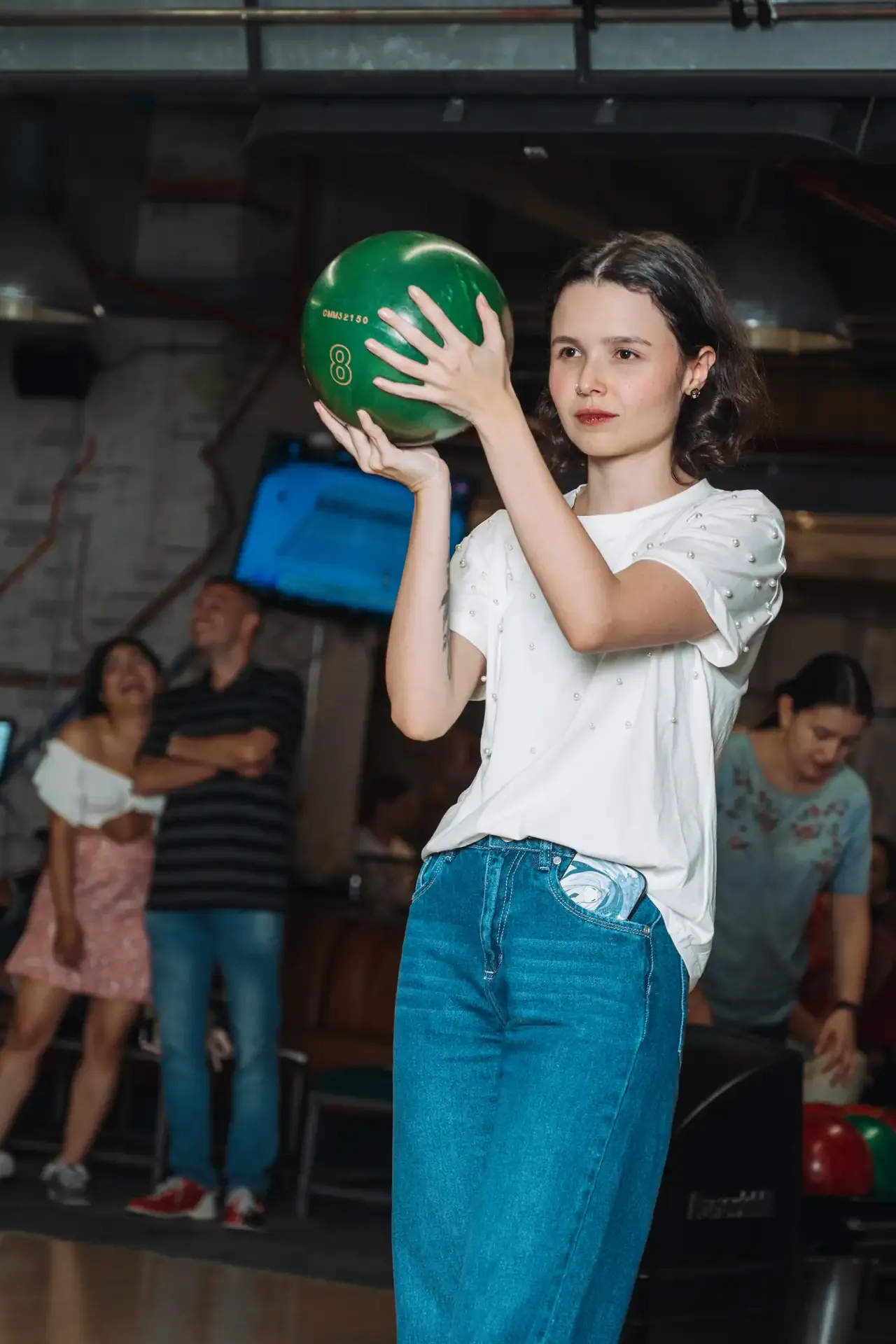 Niña sostiene una bola verde antes de su turno.