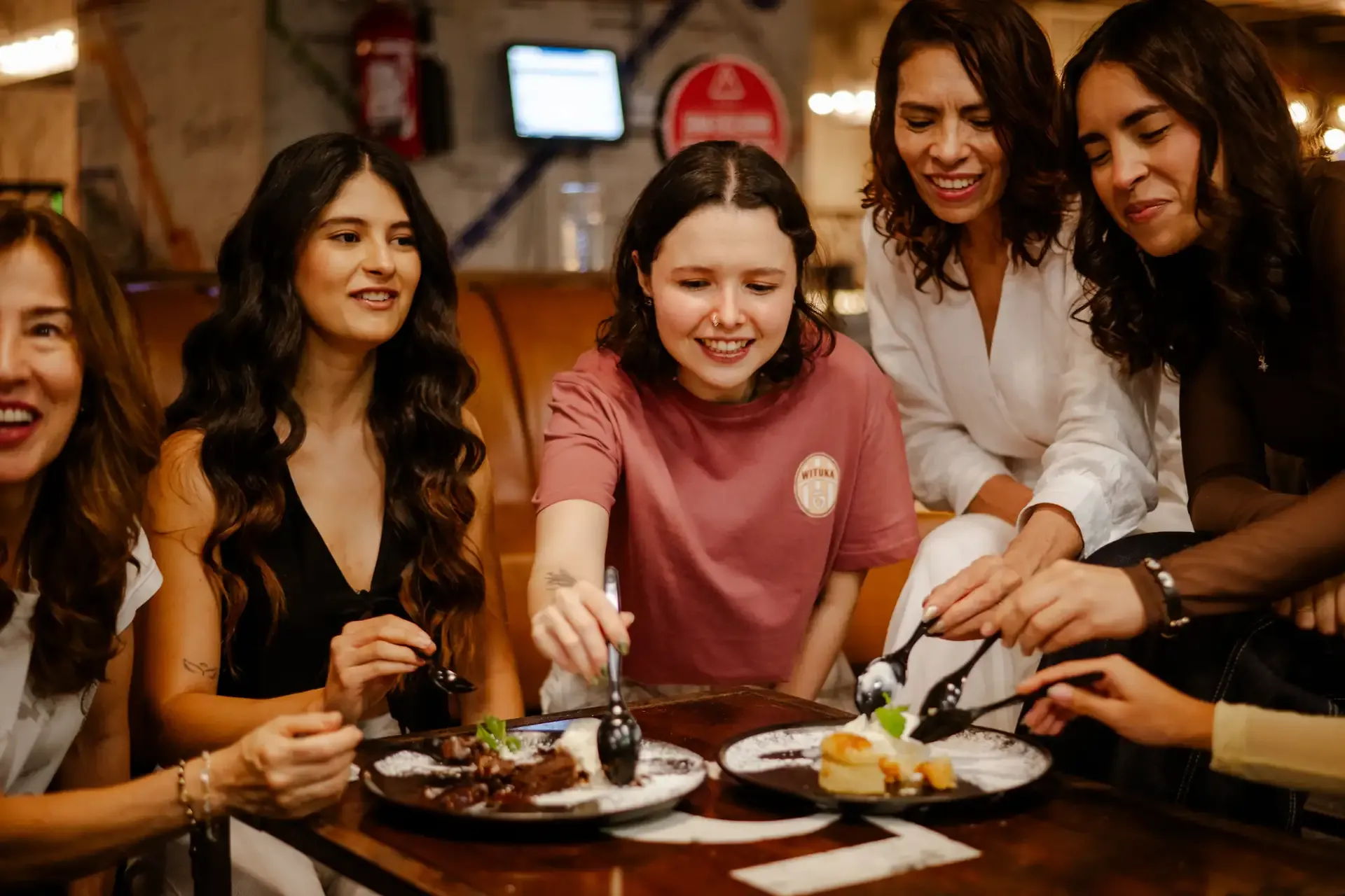 Amigas comparten una comida en la bolera.