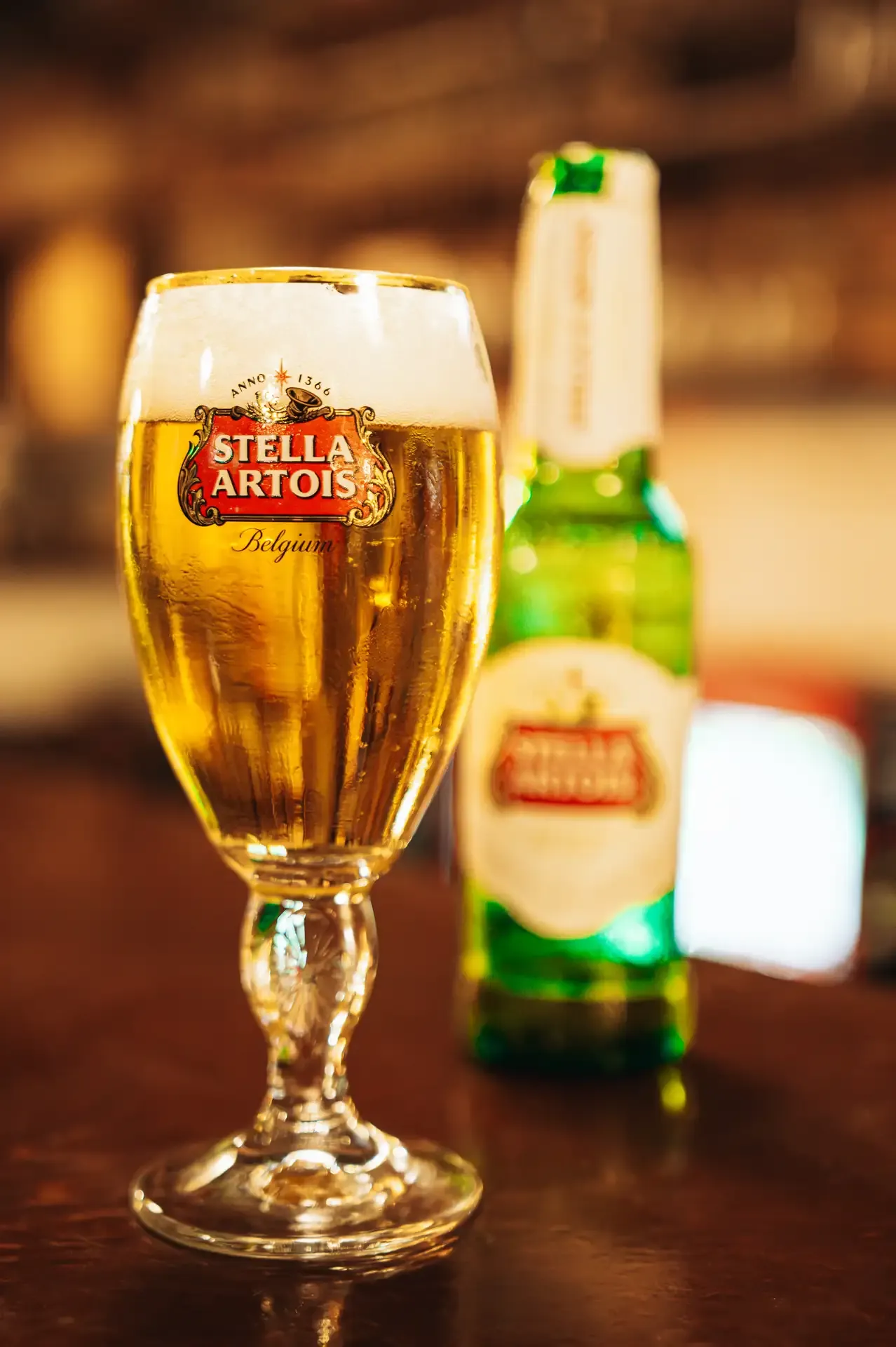 Copa de cerveza y botella sobre la barra.