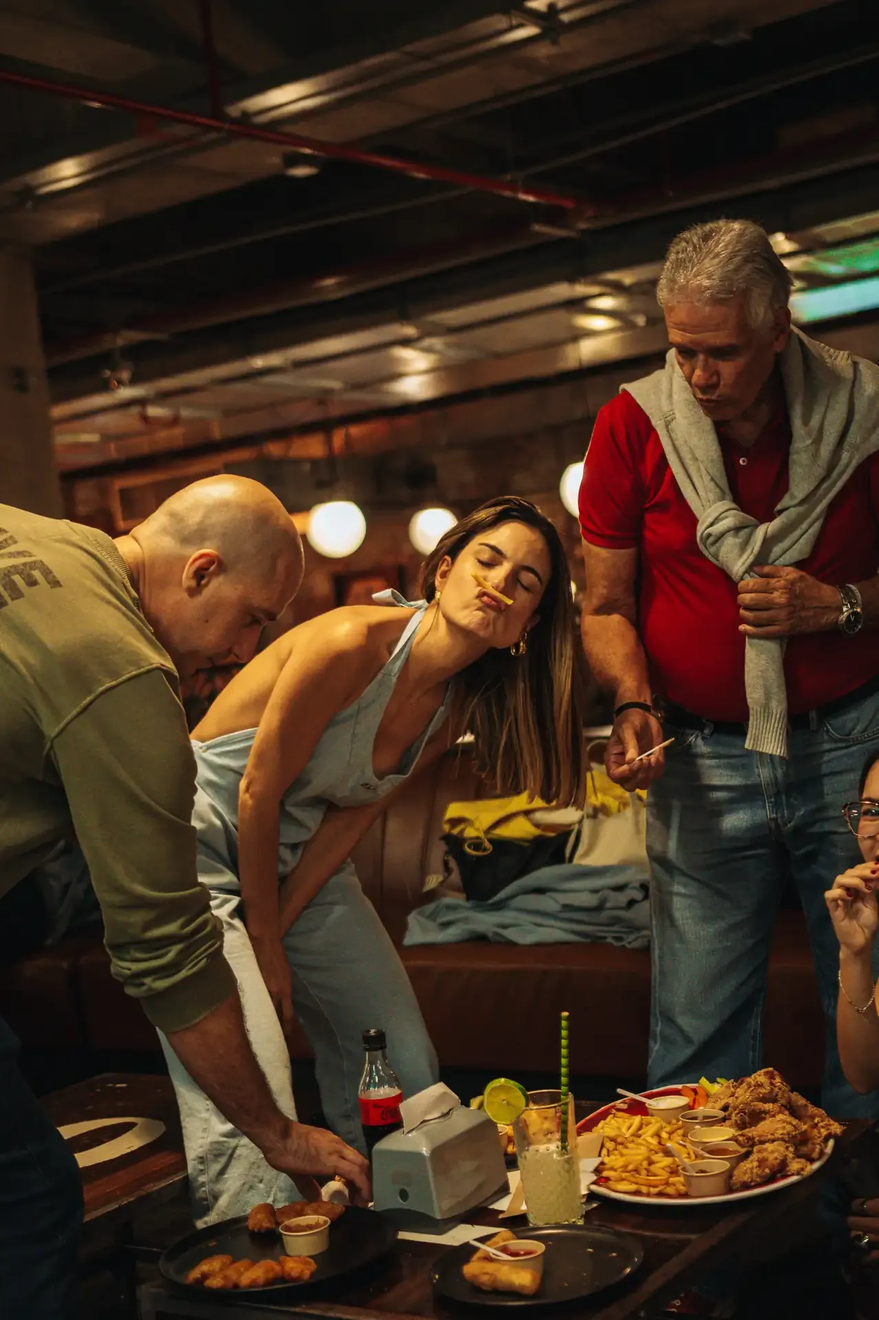 Familia comparte platos y bebidas en la mesa del restaurante.