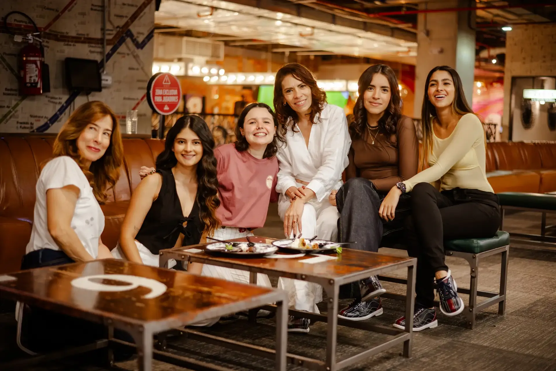 Grupo de amigas comparte una comida alrededor de la mesa.