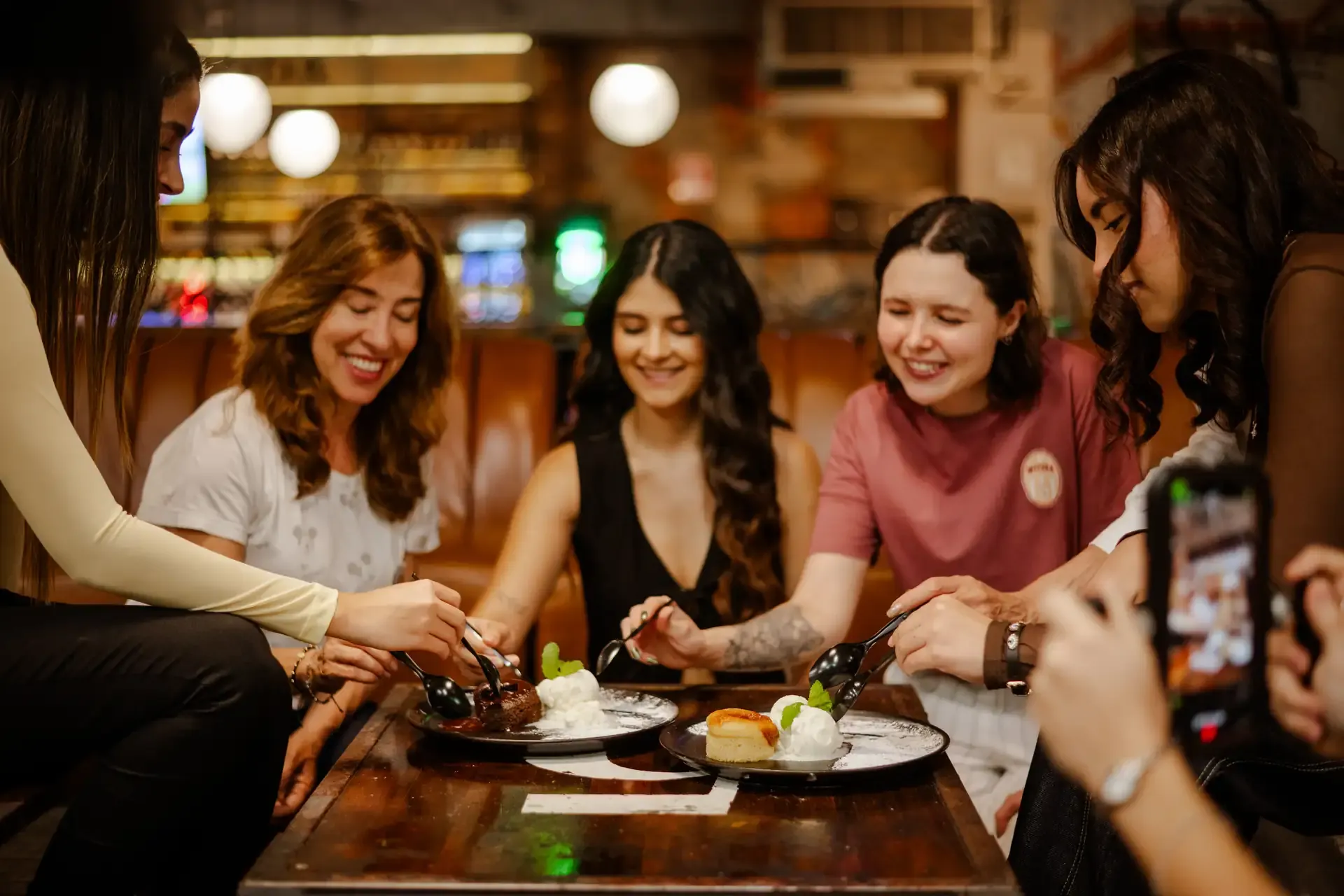 Grupo de amigas comparte comida en una mesa.