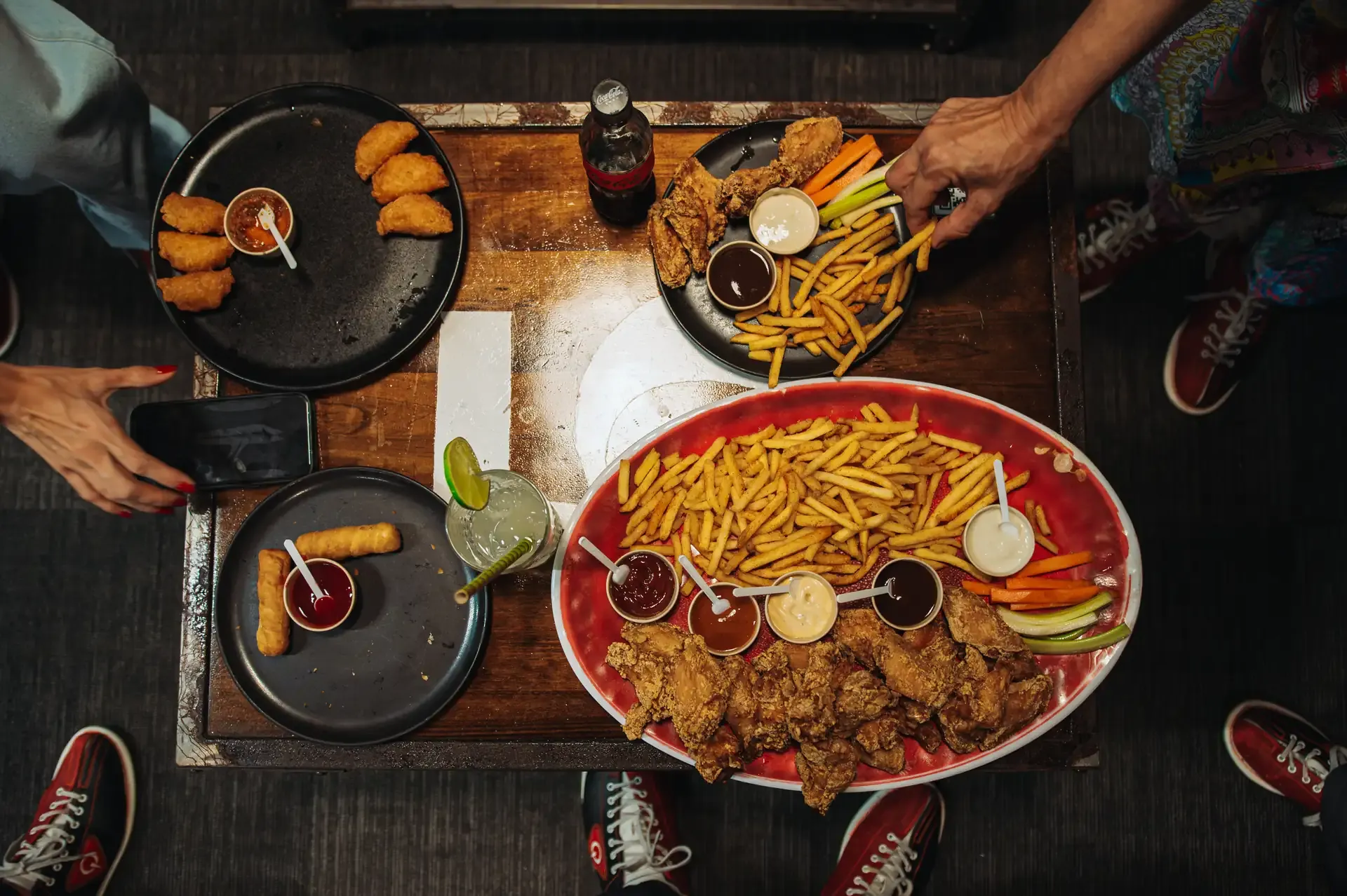 Plato para compartir con papas y acompañamientos en la mesa.
