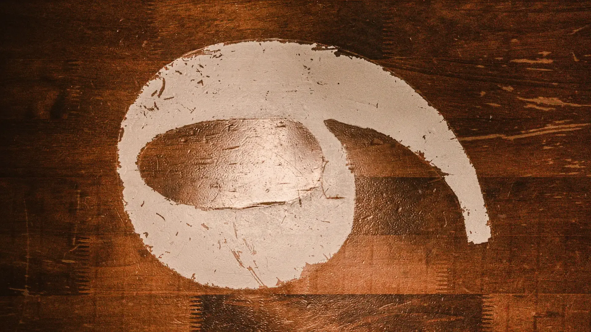 Emblema de La Industria pintado sobre una superficie de madera.