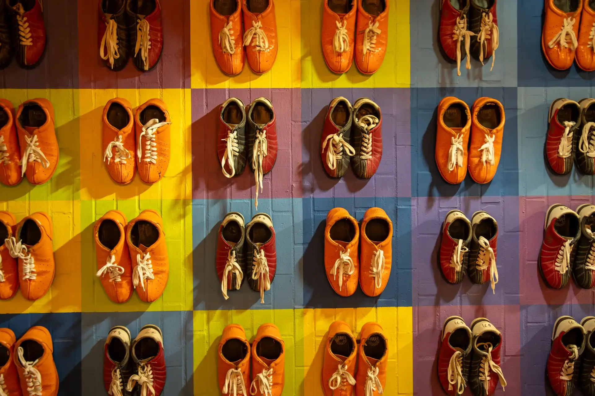 Muro de zapatos de bolos organizados por talla.