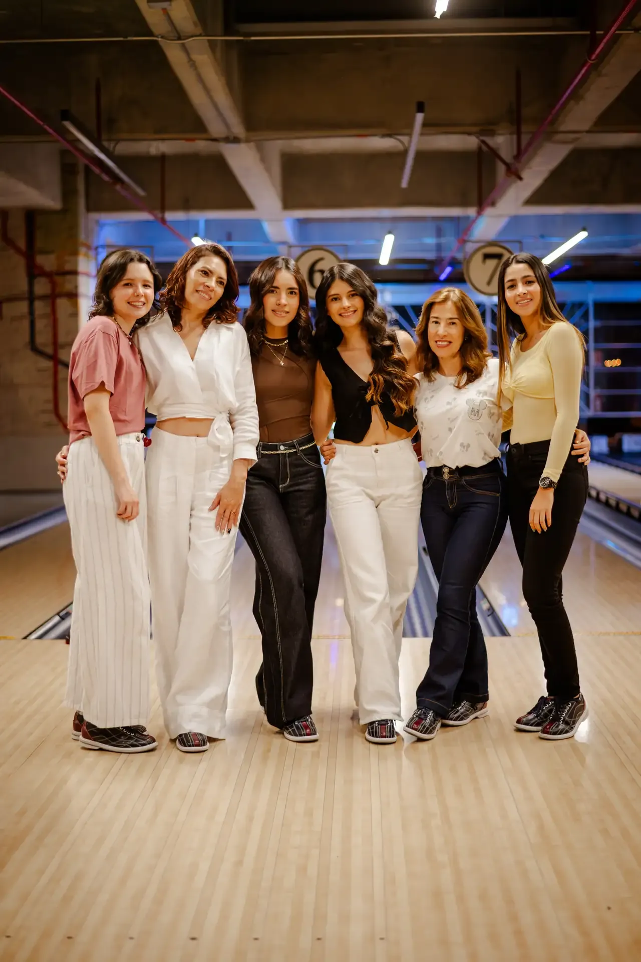 Grupo de amigas posa frente a las pistas de bolos.