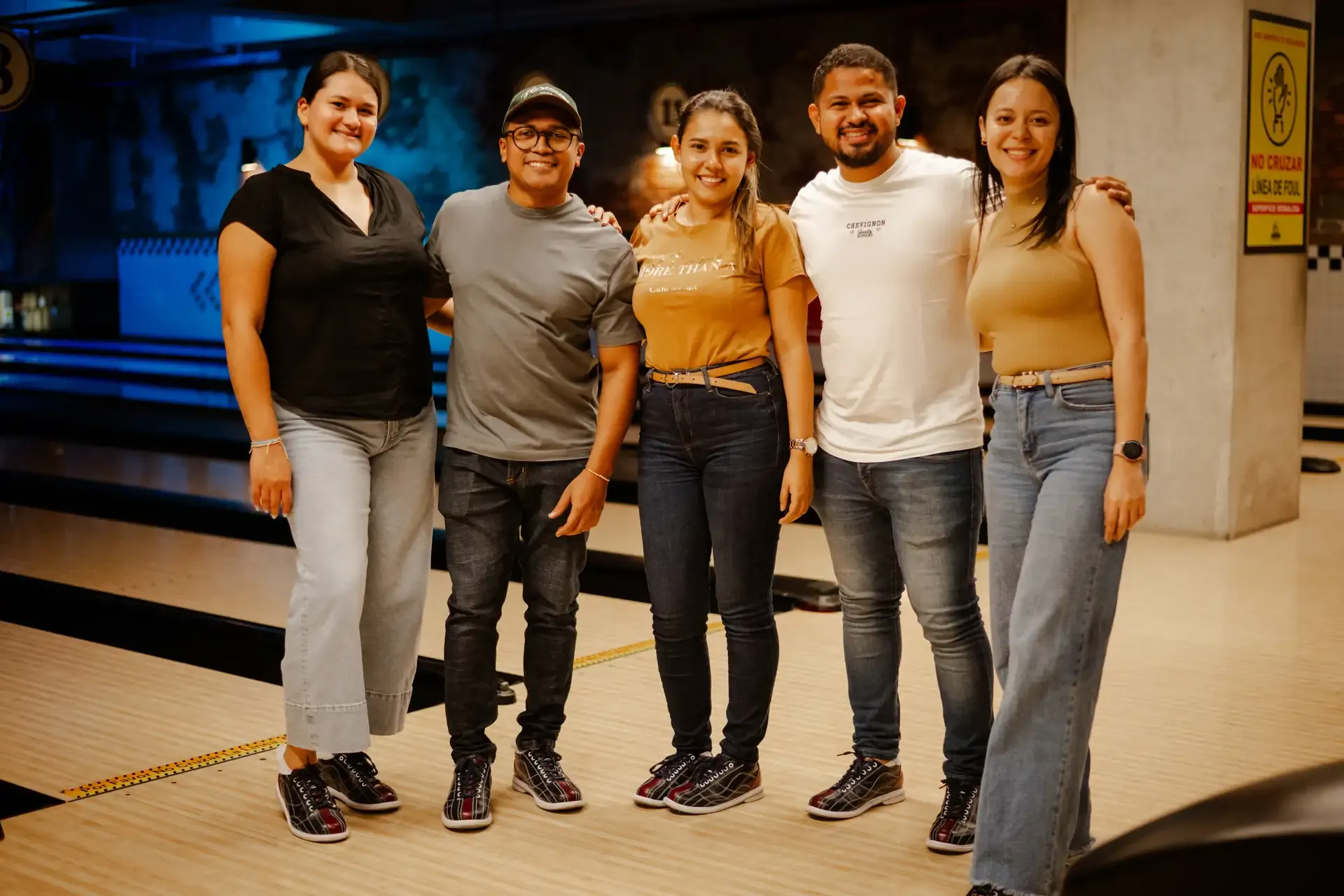 Grupo de amigos posa junto a las pistas de bolos.