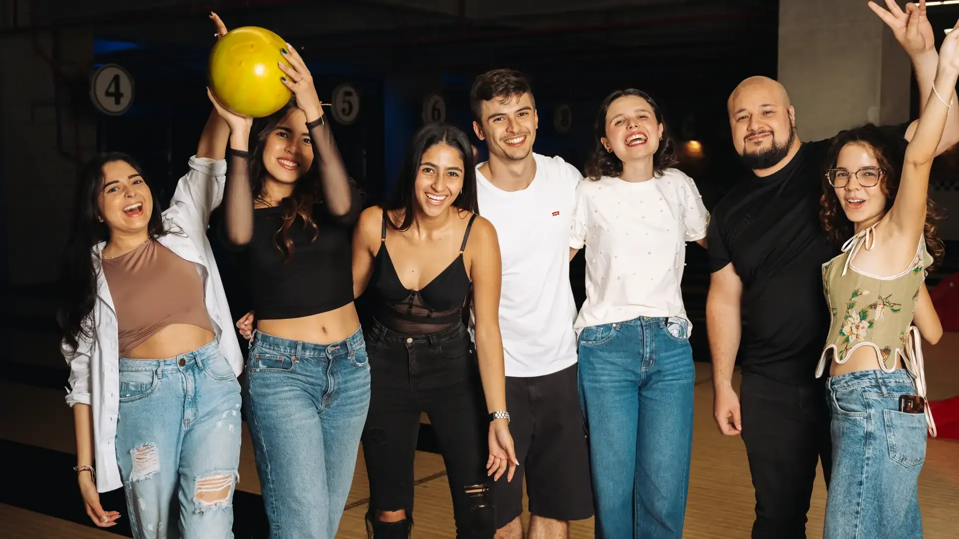 Grupo posa con una bola durante su visita a la bolera.