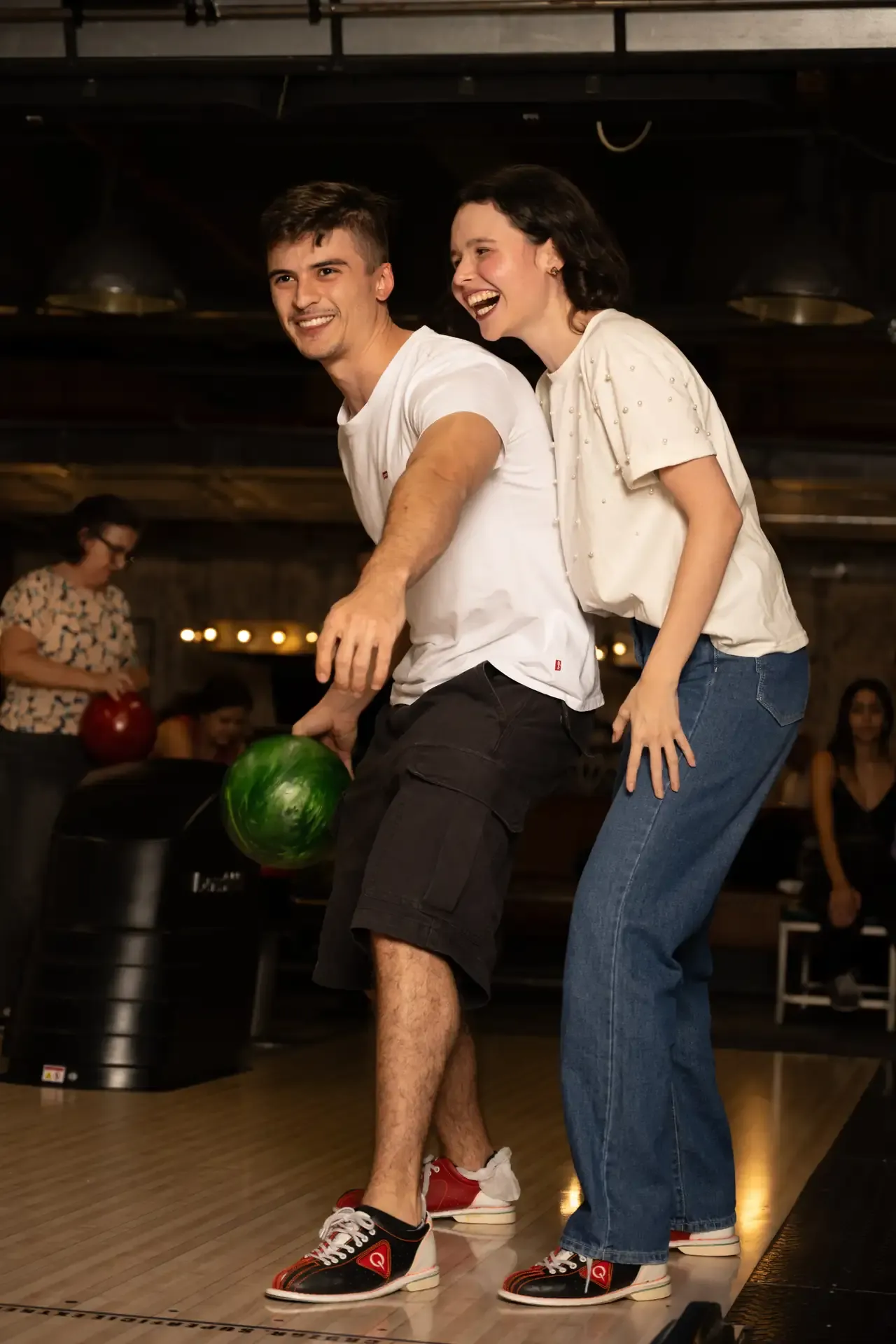 Pareja comparte una pose divertida en la bolera.